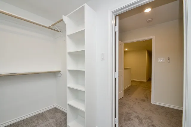 a view of an empty walk in closet and a bathroom