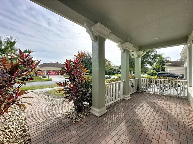a view of a porch with wooden floor next to a yard