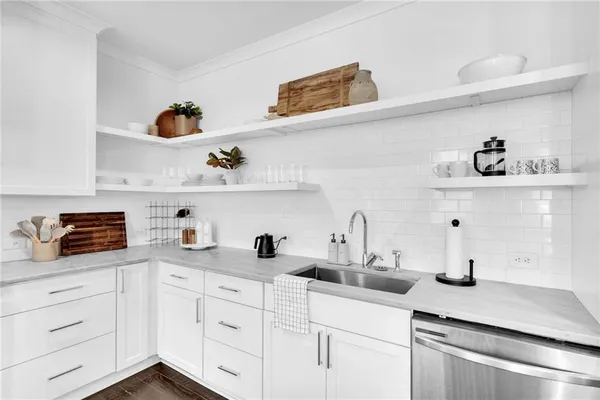 a kitchen with white cabinets and a wooden floor