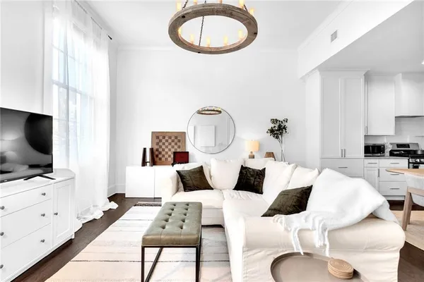 a living room with furniture a flat screen tv and a floor to ceiling window