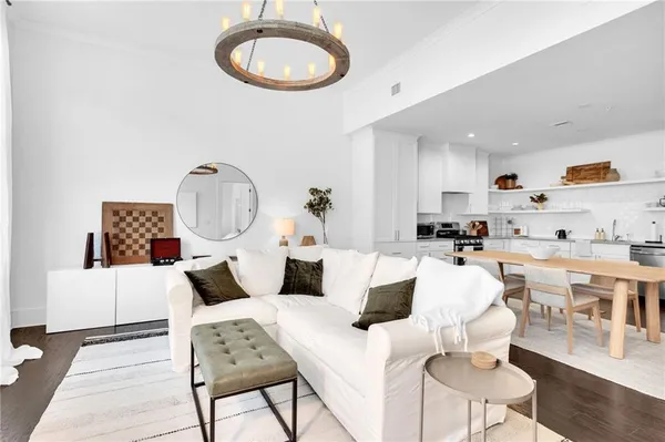 a living room with furniture a rug and kitchen view