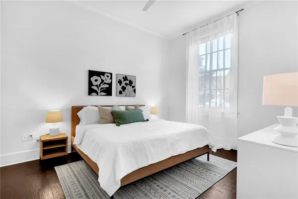 a large bed sitting in a bedroom next to a window with lamp