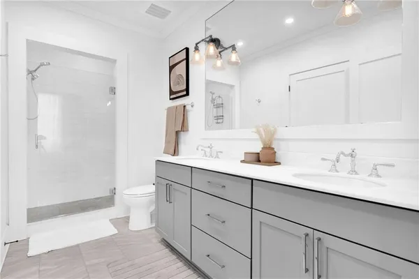 a bathroom with a sink a toilet and shower