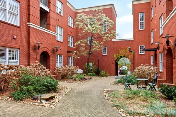 a front view of a multi story residential apartment building with a yard