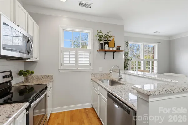 a kitchen with stainless steel appliances granite countertop a sink stove and cabinets