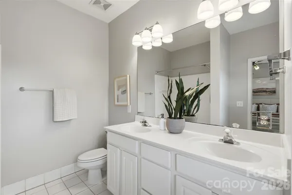 a bathroom with a toilet a sink and a large mirror