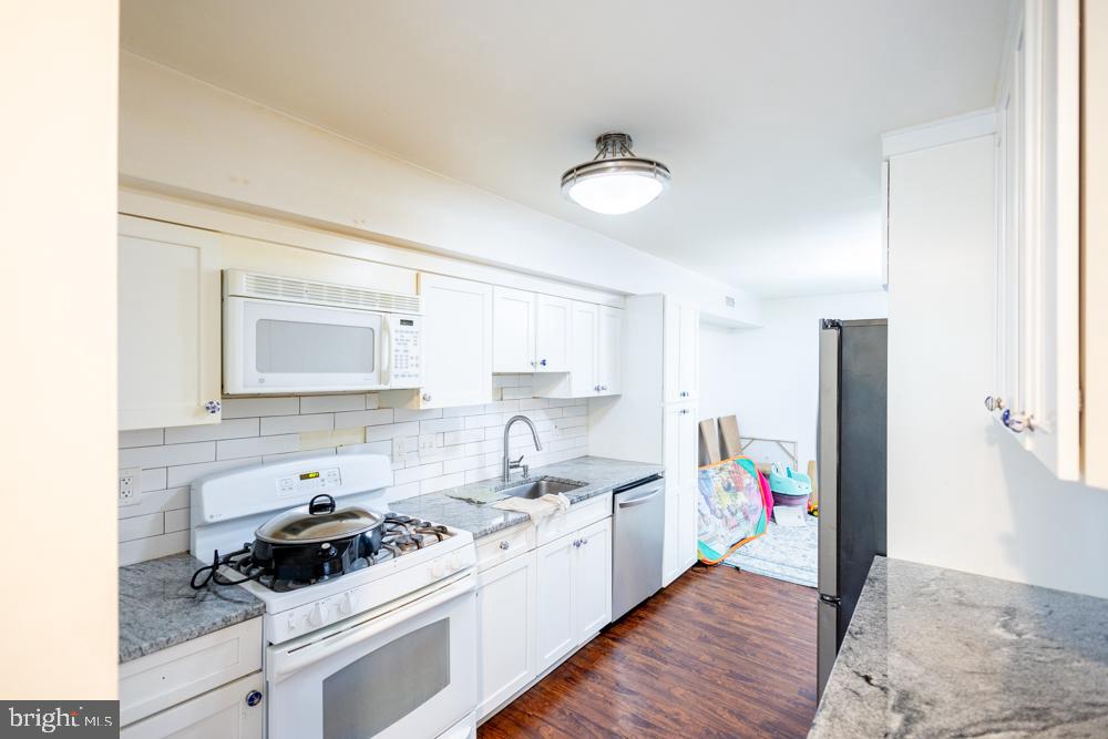 7549 Spring Lake Drive, Unit D2 Bethesda, MD 20817 - Photo 9 of 14 a kitchen with a stove a sink and a refrigerator