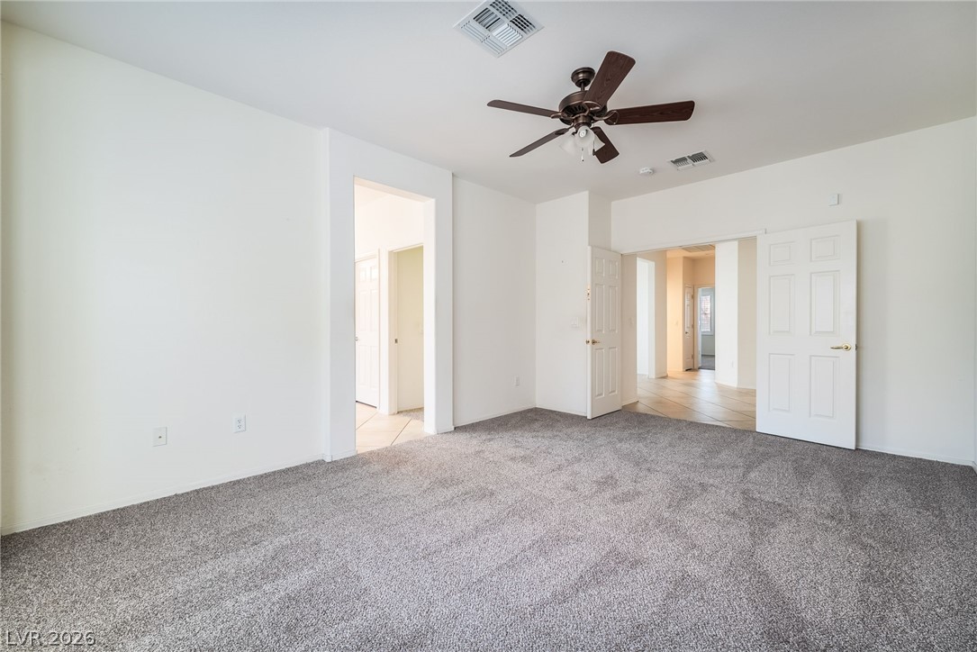 3033 Hartsville Road Henderson, NV 89052 - Photo 26 of 41 A spacious room offers comfortable carpeted flooring and a convenient ceiling fan for optimal airflow.