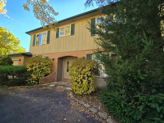 a front view of a house with plants