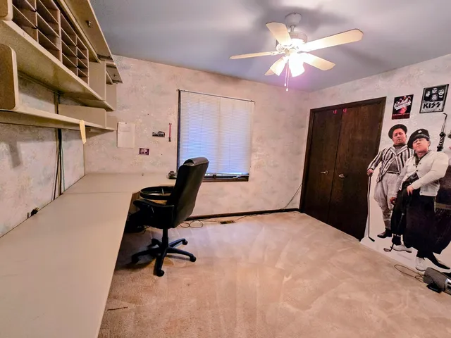 a view of a workspace with furniture and a window