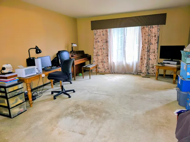 a view of a workspace with furniture and a window