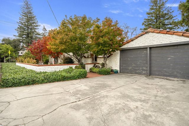 a kitchen with granite countertop white cabinets and a window