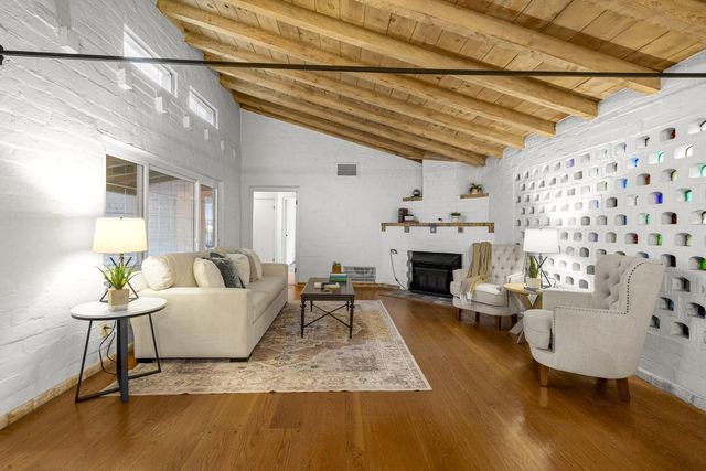 a view of a hallway to a livingroom with furniture and front door