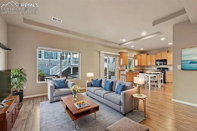 a living room with furniture wooden floor and a large window