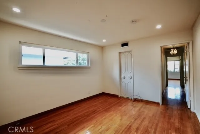 a view of a room with wooden floor and window
