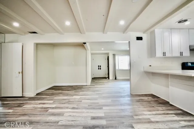 a view of an empty room with wooden cabinet