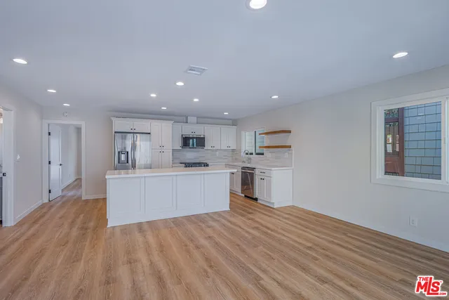 a view of empty room with wooden floor and windows