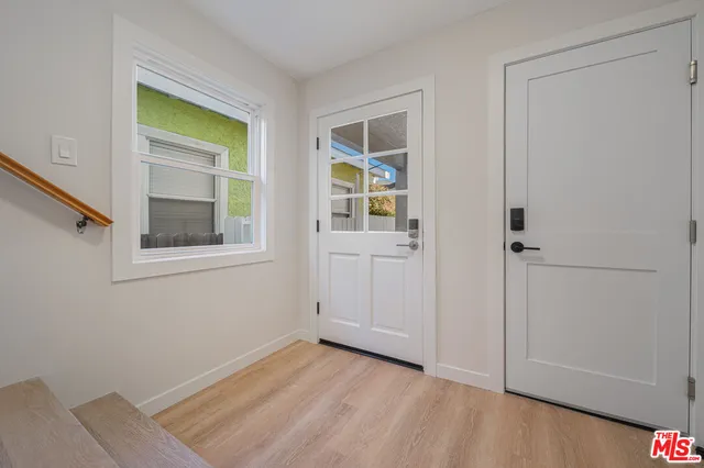 a view of a hallway with wooden floor and closet area