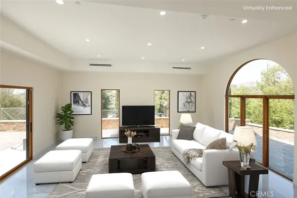 a living room with furniture a large window and a flat screen tv