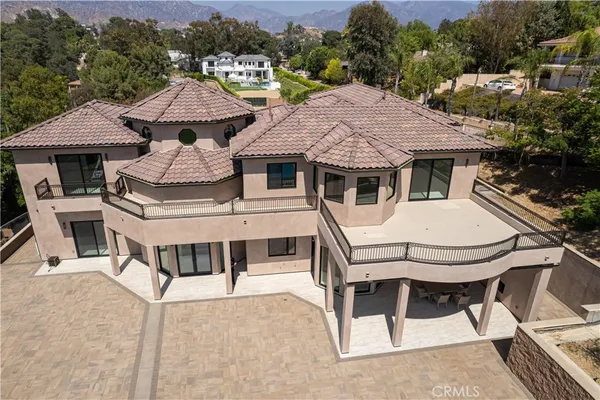 a white house with a table and chairs under an umbrella