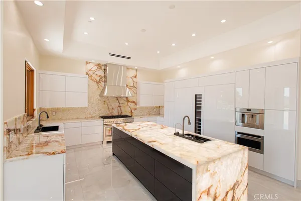 a kitchen with stainless steel appliances kitchen island granite countertop a sink and stove