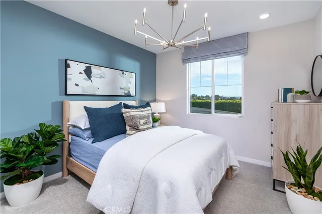 a bedroom with a large bed and a potted plant