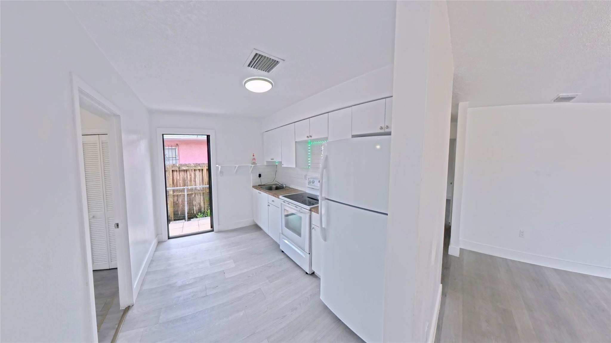 2620 Southwest 32nd Avenue Miami, FL 33133 - Photo 11 of 19 a kitchen with white cabinets and white appliances