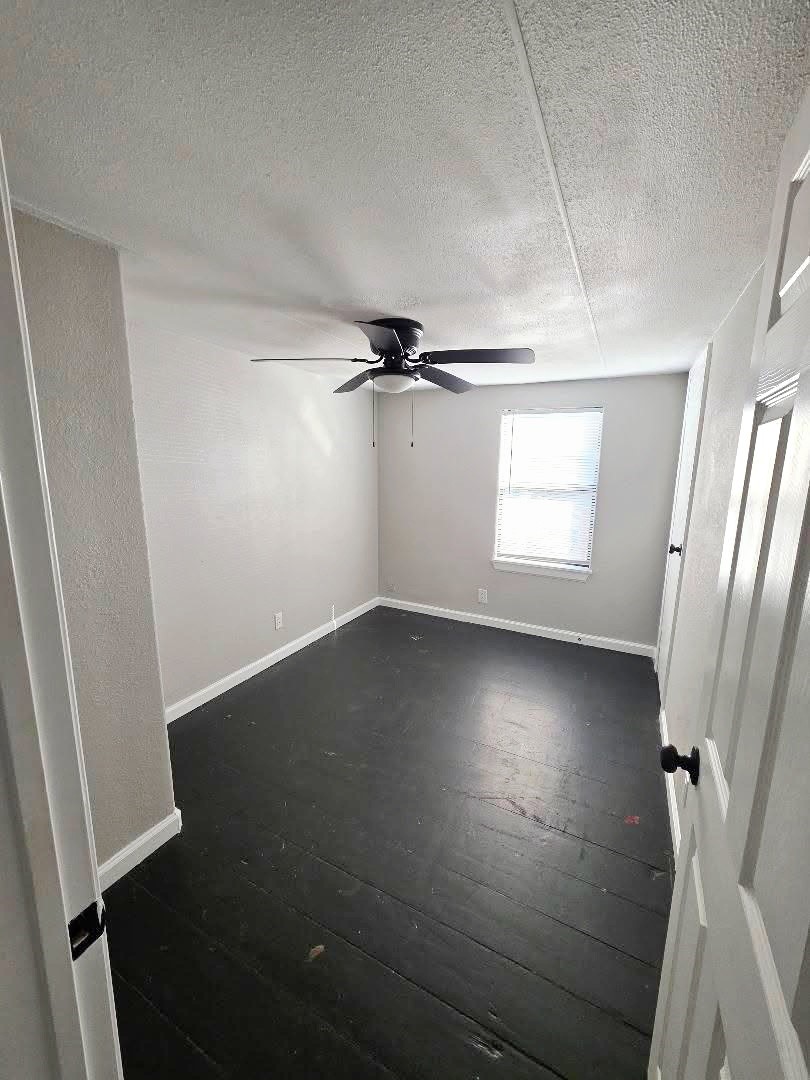 310 Paddock Street, Unit 5 Willis, TX 77378 - Photo 11 of 12 an empty room with wooden floor and windows