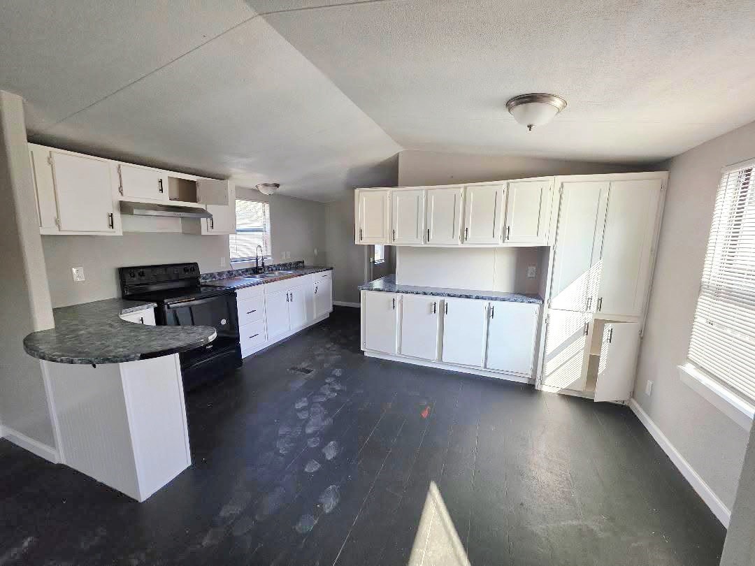 310 Paddock Street, Unit 5 Willis, TX 77378 - Photo 4 of 12 a kitchen with stainless steel appliances a sink a stove a refrigerator cabinets and a window
