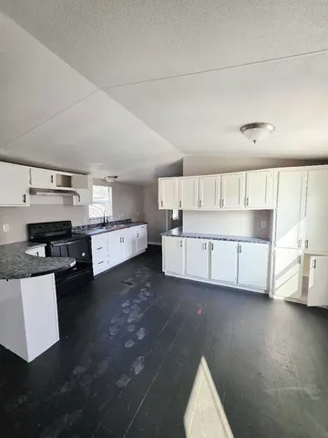 a living room with furniture and kitchen view