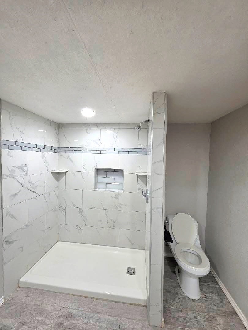 310 Paddock Street, Unit 5 Willis, TX 77378 - Photo 8 of 12 a bathroom with a shower and a toilet