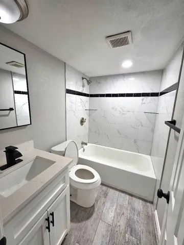a bathroom with a sink a toilet a mirror and bathtub
