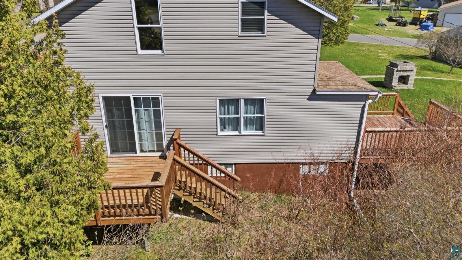 50 Main Street Soudan, MN 55782 - Photo 29 of 31 Rear exterior featuring gray vinyl siding and a multi-level wooden deck