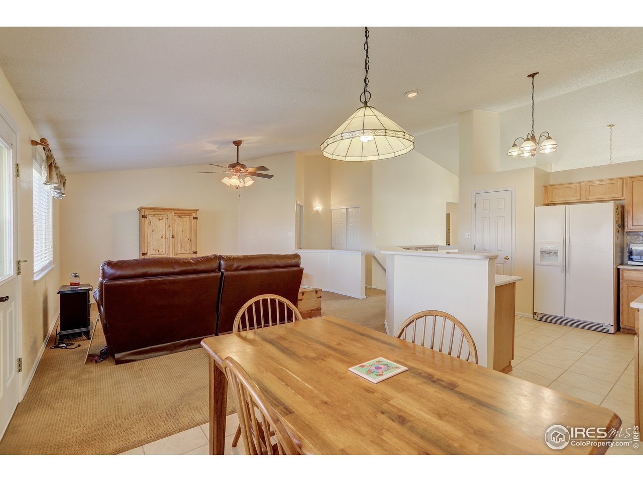 5403 Bobcat Street Frederick, CO 80504 - Photo 11 of 40 a view of a dining room with furniture a chandelier and a window