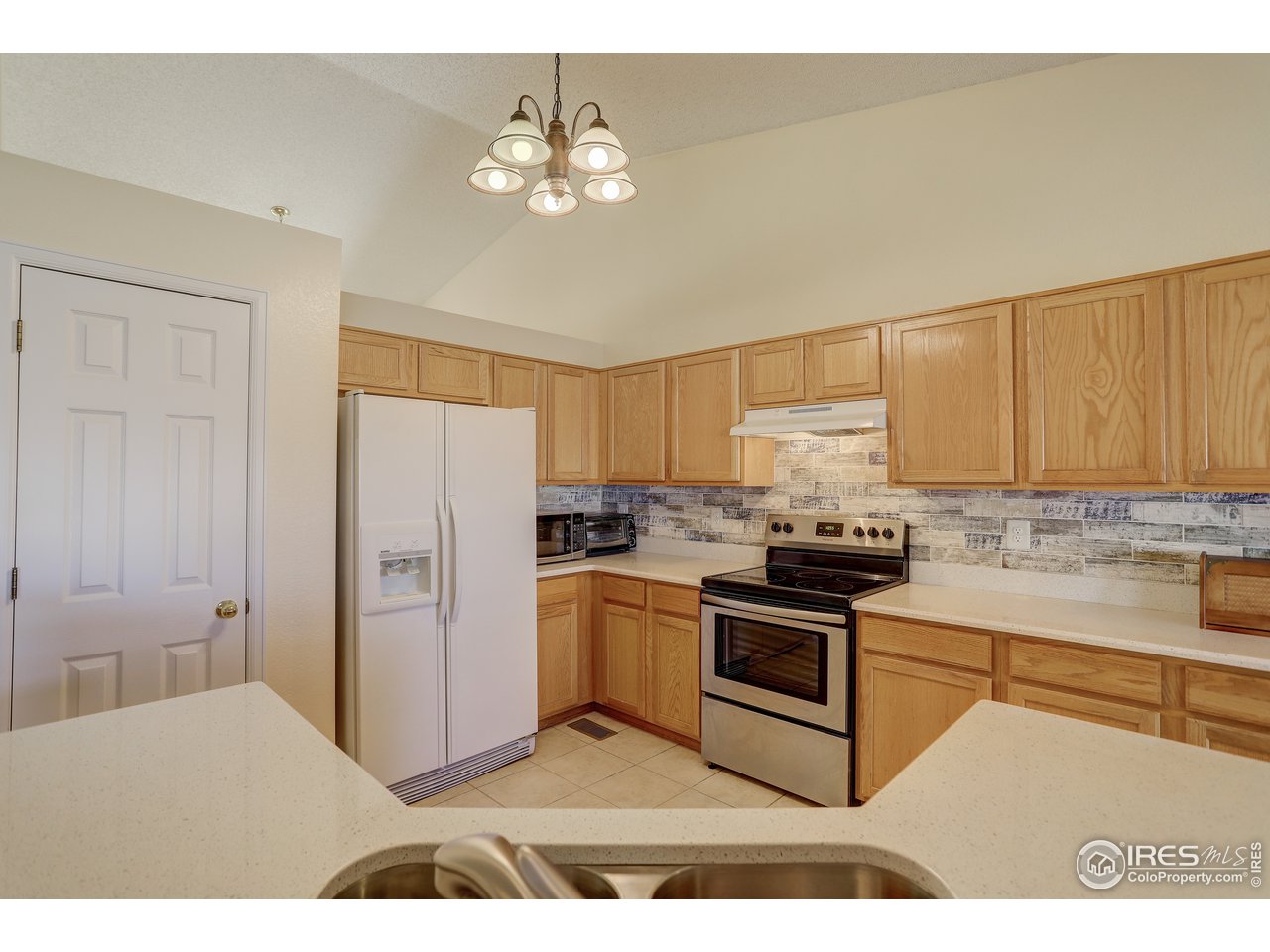 5403 Bobcat Street Frederick, CO 80504 - Photo 16 of 40 a kitchen with stainless steel appliances granite countertop a stove a sink dishwasher and a refrigerator