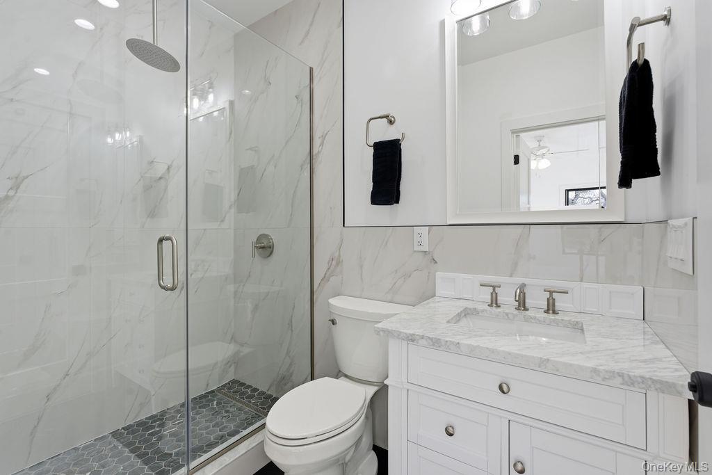 768 Bridgehampton Sag Harbor Bridgehampton, NY 11932 - Photo 26 of 35 Bathroom with tile walls, vanity, a marble finish shower, tasteful backsplash, and ceiling fan
