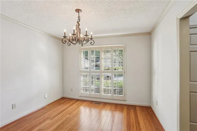 a view of a room with wooden floors and chandelier