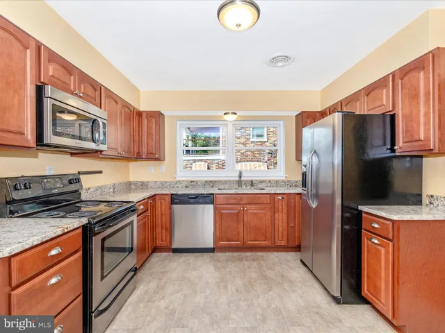a kitchen with stainless steel appliances granite countertop a stove a refrigerator and a microwave