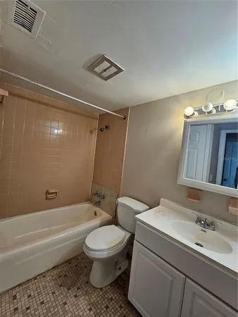 a bathroom with a toilet sink vanity tub and shower