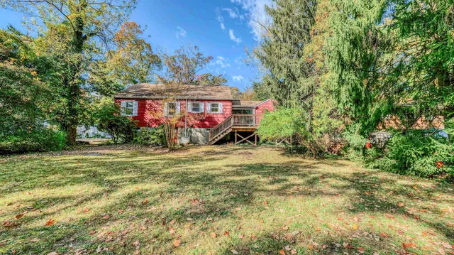a front view of house with yard and trees in the background