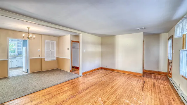 a view of empty room with wooden floor and cabinet