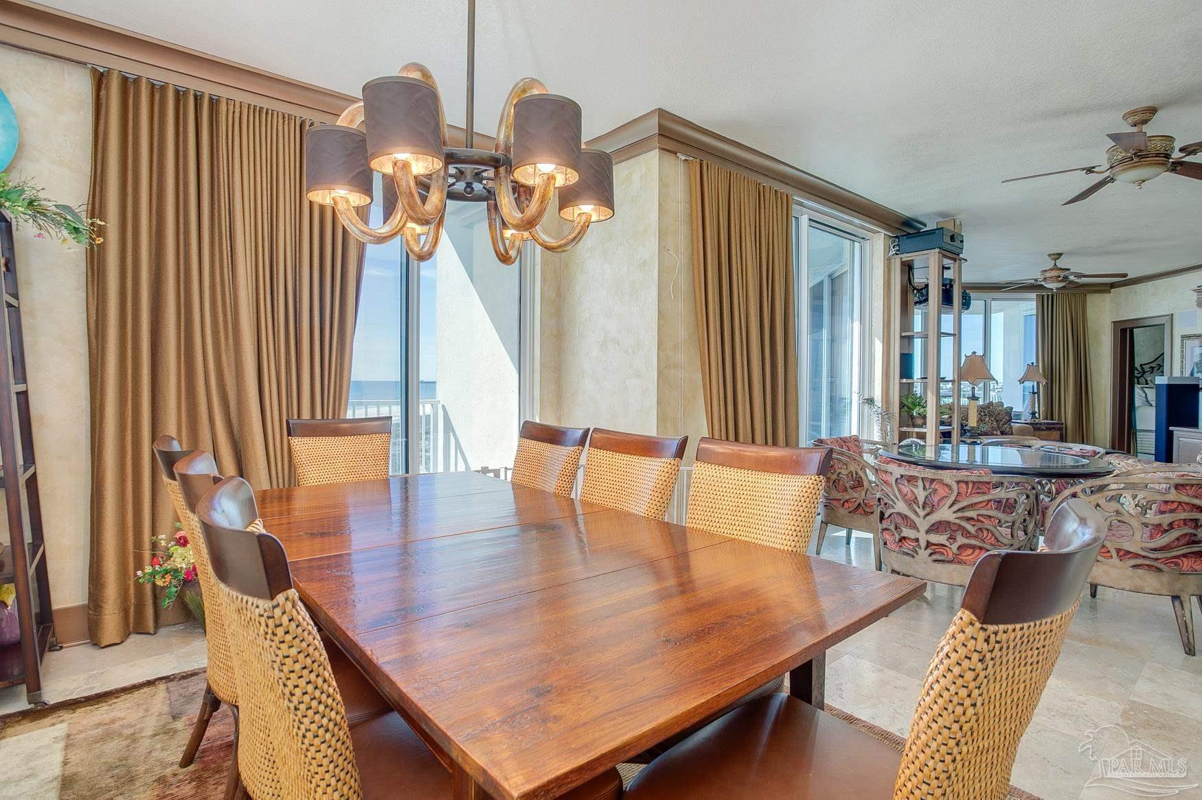 16795 Perdido Key Drive, Unit 40304B Perdido Key, FL 32507 - Photo 29 of 42 a dining room with wooden floor a chandelier a wooden table and chairs
