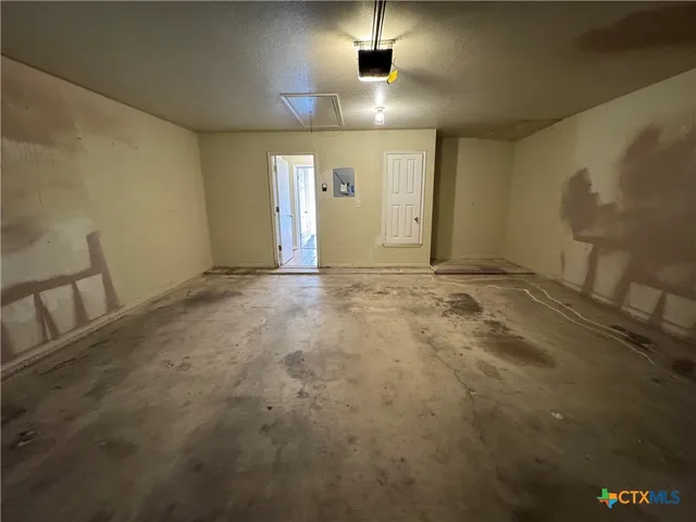 en empty room with windows and fireplace