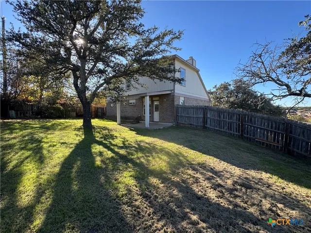 a view of a house with backyard and tree