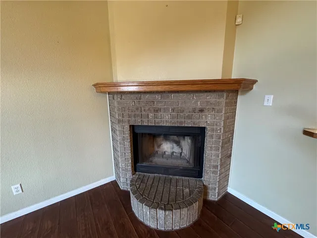 a living room with a fireplace and wooden floor