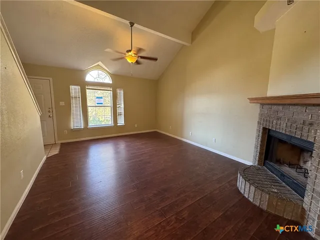 wooden floor fireplace and windows in an empty room