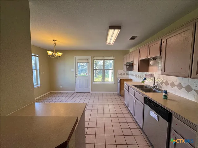a large kitchen with kitchen island a sink stainless steel appliances and cabinets