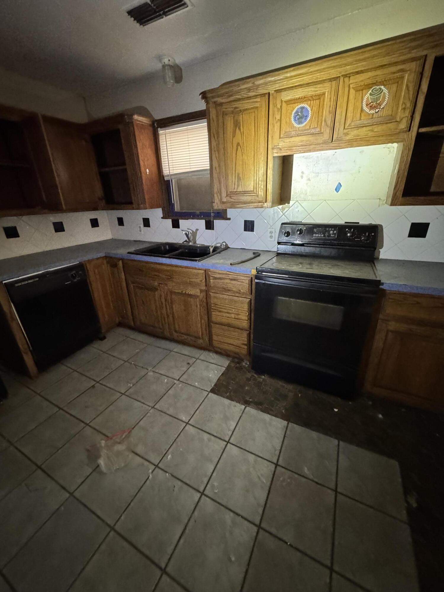 2119 26th Street Lubbock, TX 79411 - Photo 6 of 15 a kitchen with stainless steel appliances a stove a sink and a microwave