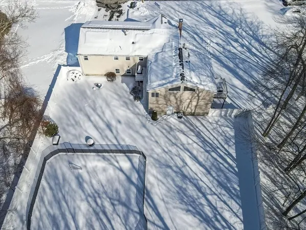 a front view of a house with a yard covered with snow in front of house