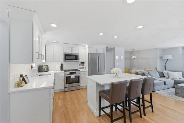 a large kitchen with kitchen island a dining table and chairs